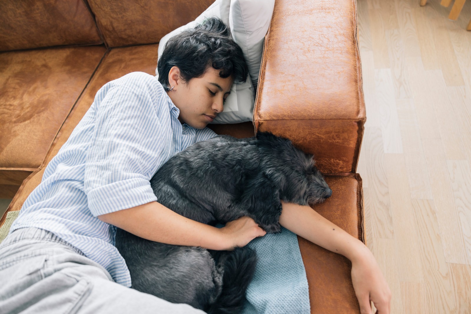 Boy cuddling with his dog on the couch
